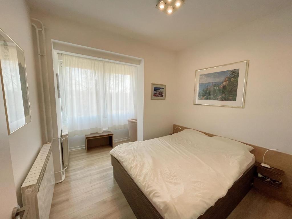um pequeno quarto com uma cama e uma janela em Top Art Topusko Apartments em Topusko
