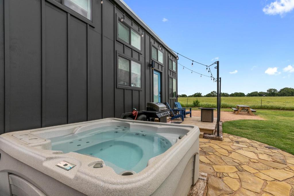 a hot tub sitting outside of a house at NEW Luxury Tiny Home with Hot Tub and Grill in Fredericksburg