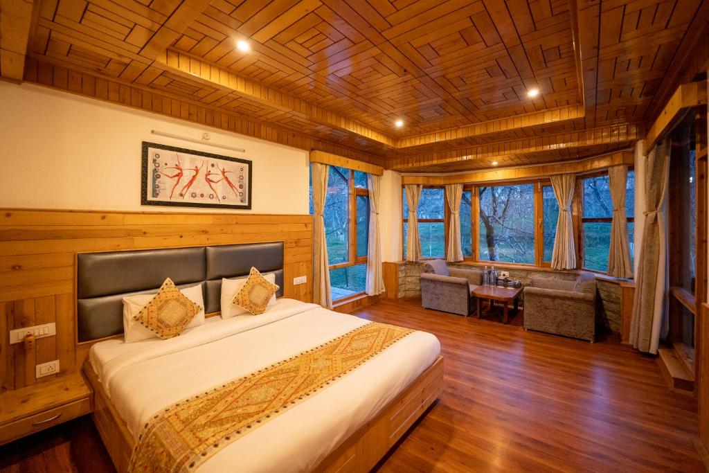 a bedroom with a large bed in a room with wooden ceilings at Amarys Boutique Stays Manali in Manāli