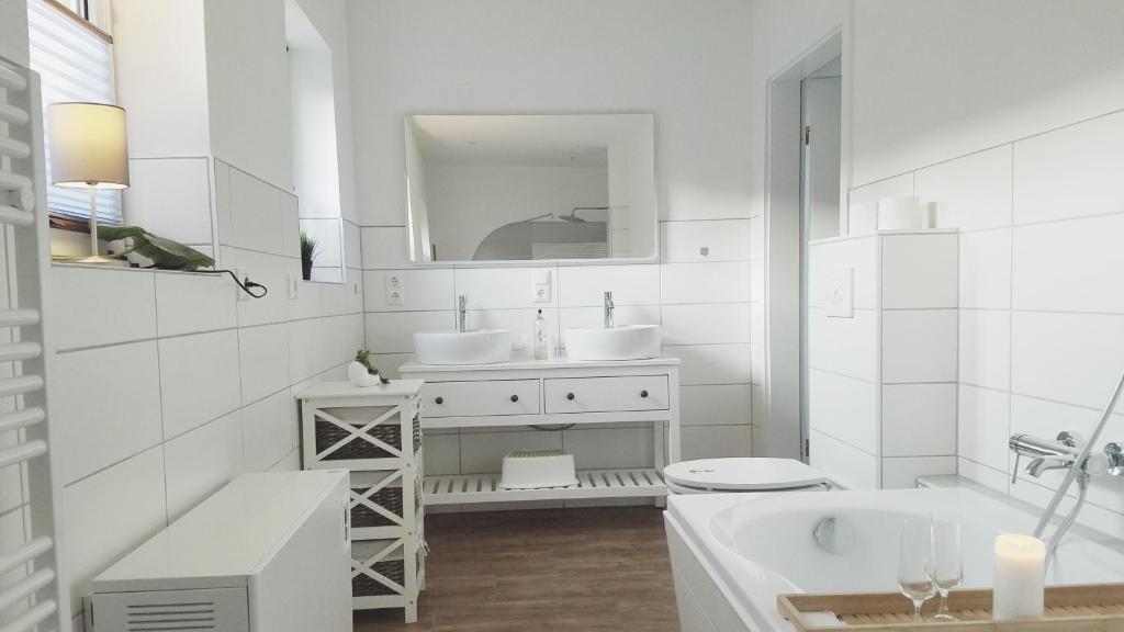 a white bathroom with two sinks and a mirror at Ferienhaus Kranich in Federow