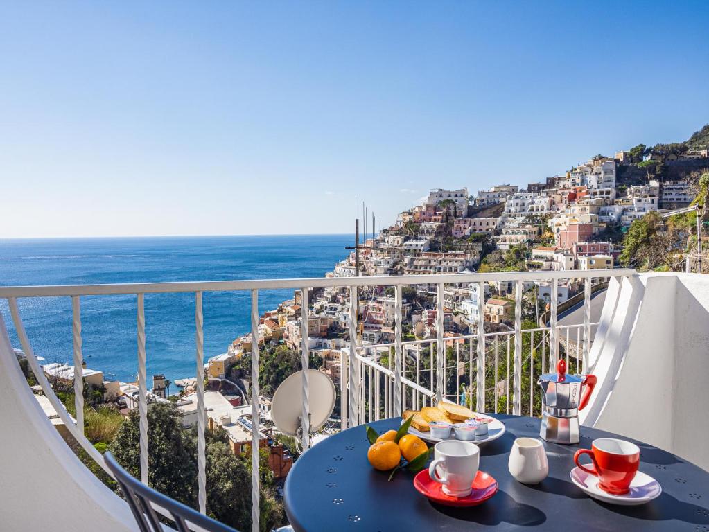 a table on a balcony with a view of the ocean at La Perla di Chicca in Positano