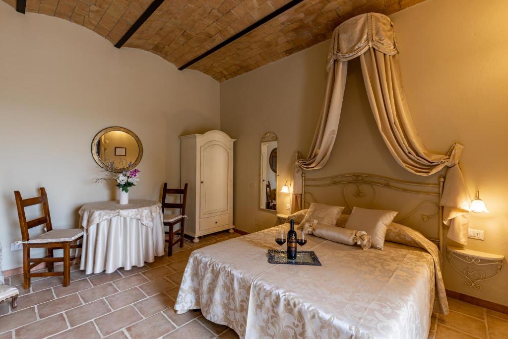 a bedroom with a bed and a table and chairs at Wine Resort Colsereno in Montalcino