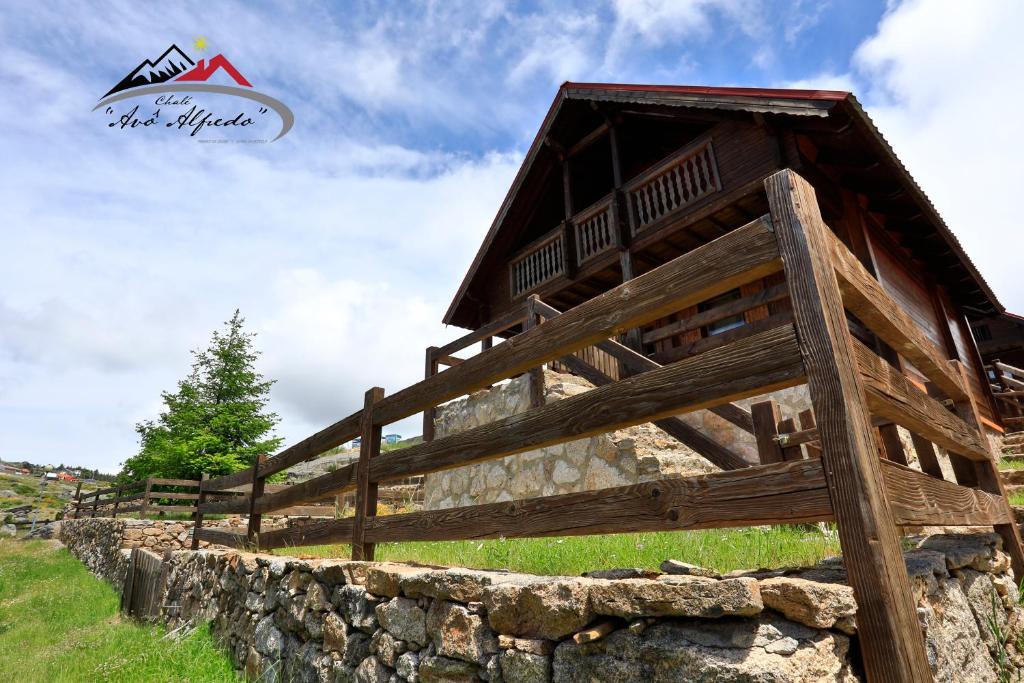 a wooden fence next to a stone wall at Chalé Avô Alfredo in Cortes do Meio