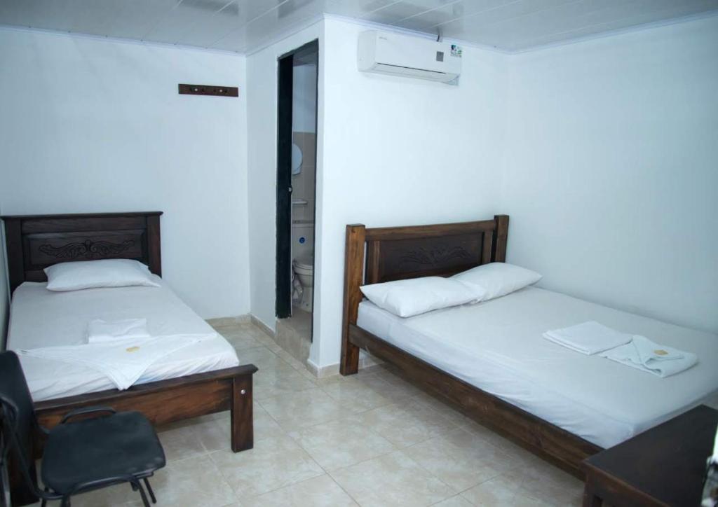 Postel nebo postele na pokoji v ubytování Aparta Hotel El Cacique Upar