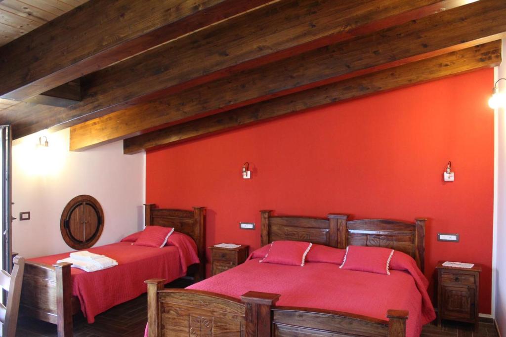 2 letti in una camera con pareti rosse di The Chalet, guest house ad Agerola