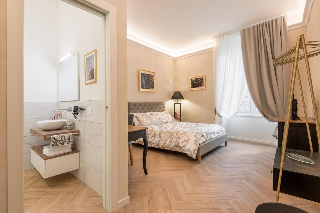 a bedroom with a bed and a sink and a mirror at Classic Chic - Città Alta in Bergamo