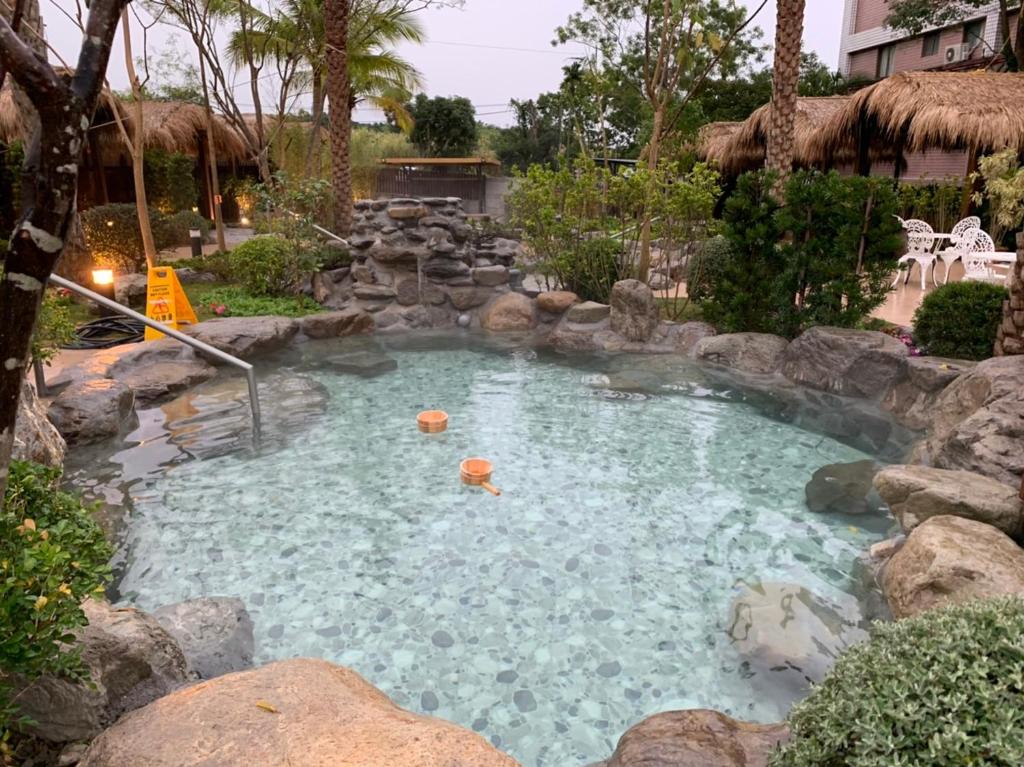 a swimming pool with a rock retaining wall and a pool at Yawan Hotel in Wenquan