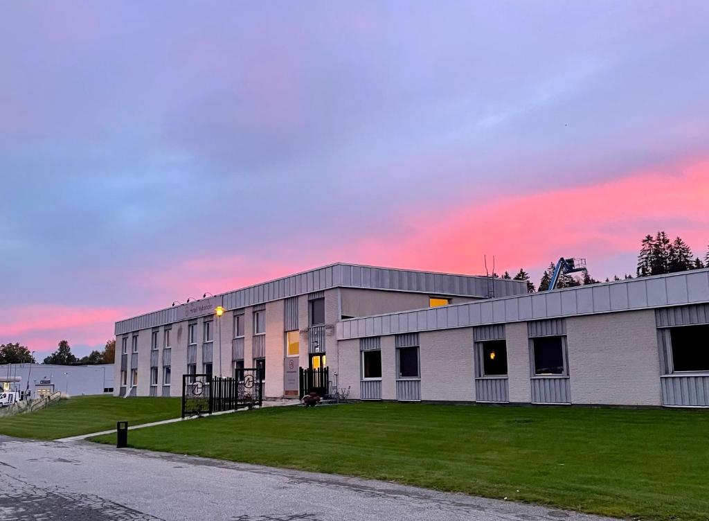 a large building with a sunset in the background at Hotell Nyboholm in Ulricehamn