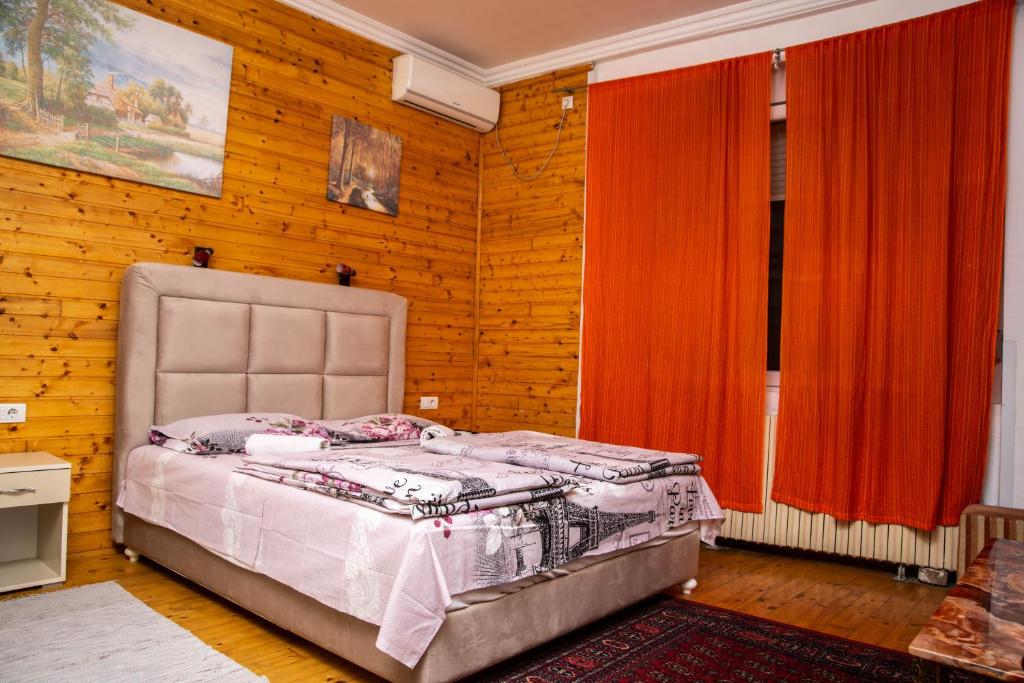 um quarto com uma cama num quarto com paredes de madeira em Sobe sa sopstvenim KUPATILOM Private rooms bathroom In CENTER em Novi Sad