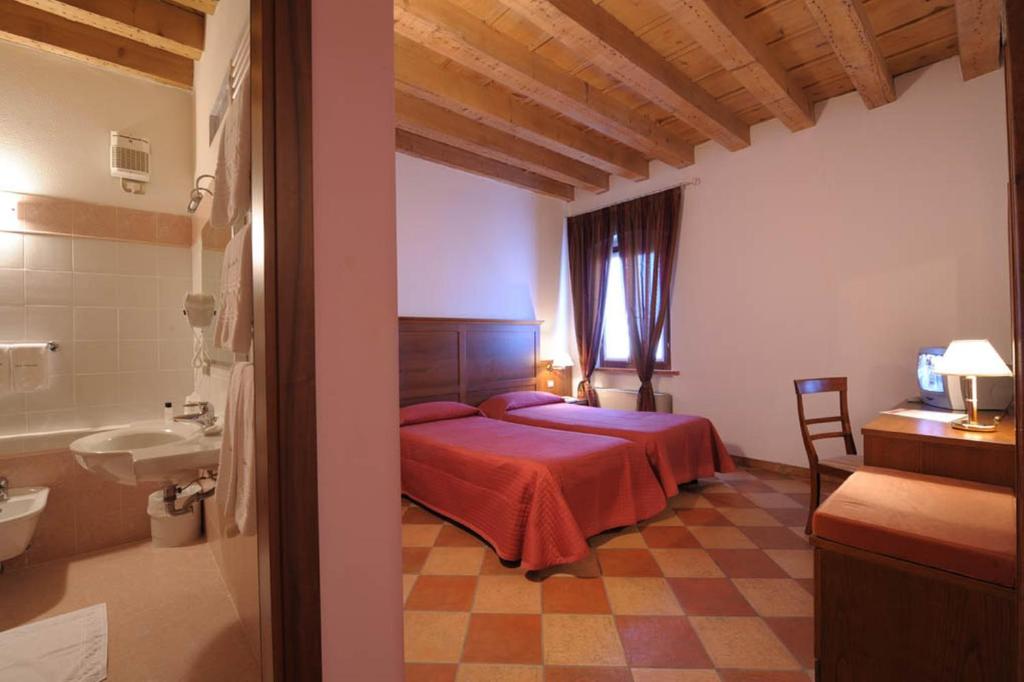 Postel nebo postele na pokoji v ubytování Corte Castelletto