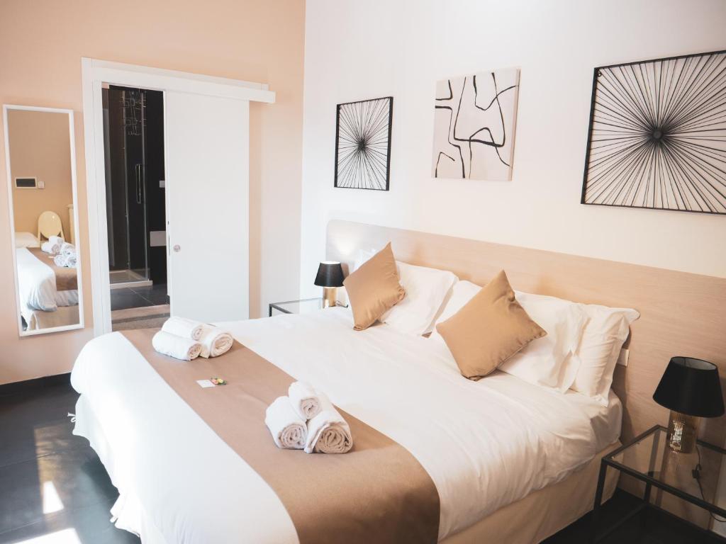Un dormitorio con una gran cama blanca con toallas. en DhOME B&B, en Palermo