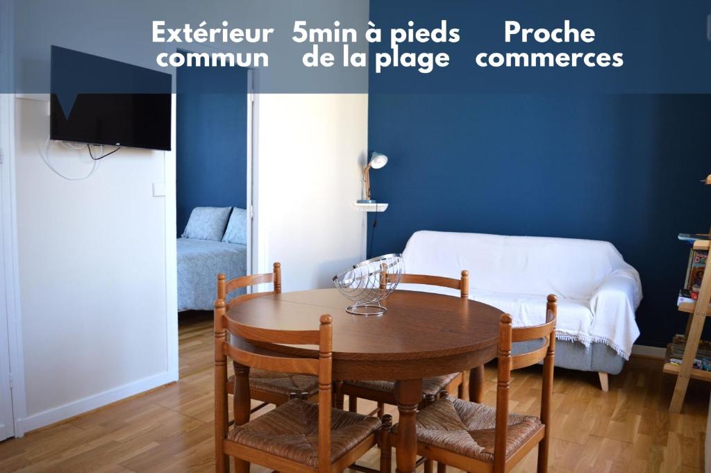 a dining room with a table and a couch at Appart à 2 pas de la plage - Centre d'Asnelles in Asnelles