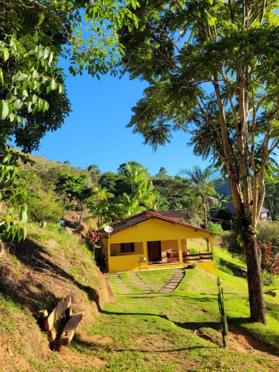 a yellow house on the side of a hill at Espaço inteiro: Casa de campo nas montanhas in Domingos Martins