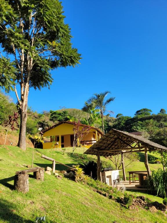 ein Haus mit einem Picknicktisch und einem Baum in der Unterkunft Espaço inteiro: Casa de campo nas montanhas in Domingos Martins