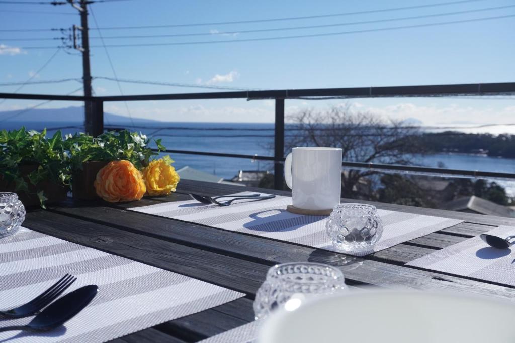 a dining table with a view of the ocean at Luana Marue in Ito