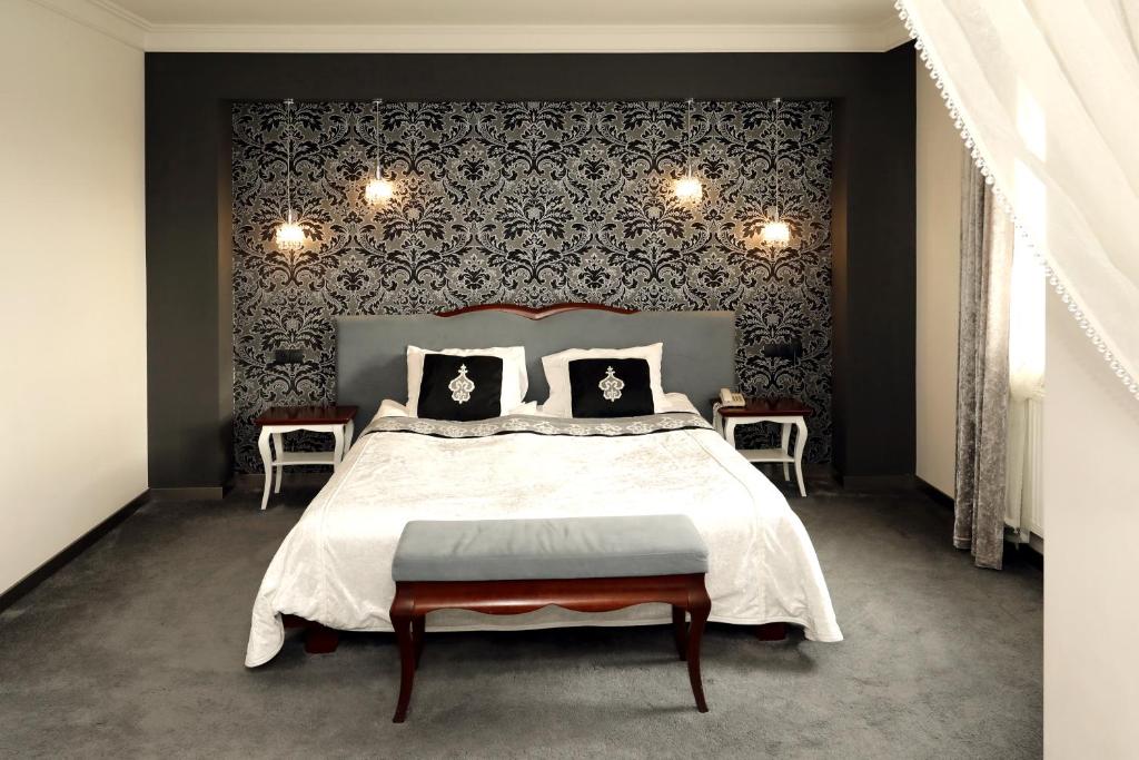 a bedroom with a large bed with a black wall at Biały Dom Henlex Hotel Restauracja in Poznań