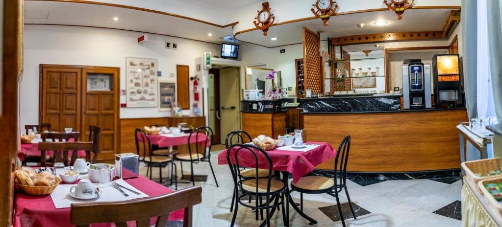 un restaurante con mesas y sillas y un bar en Hotel Ferrarese en Roma