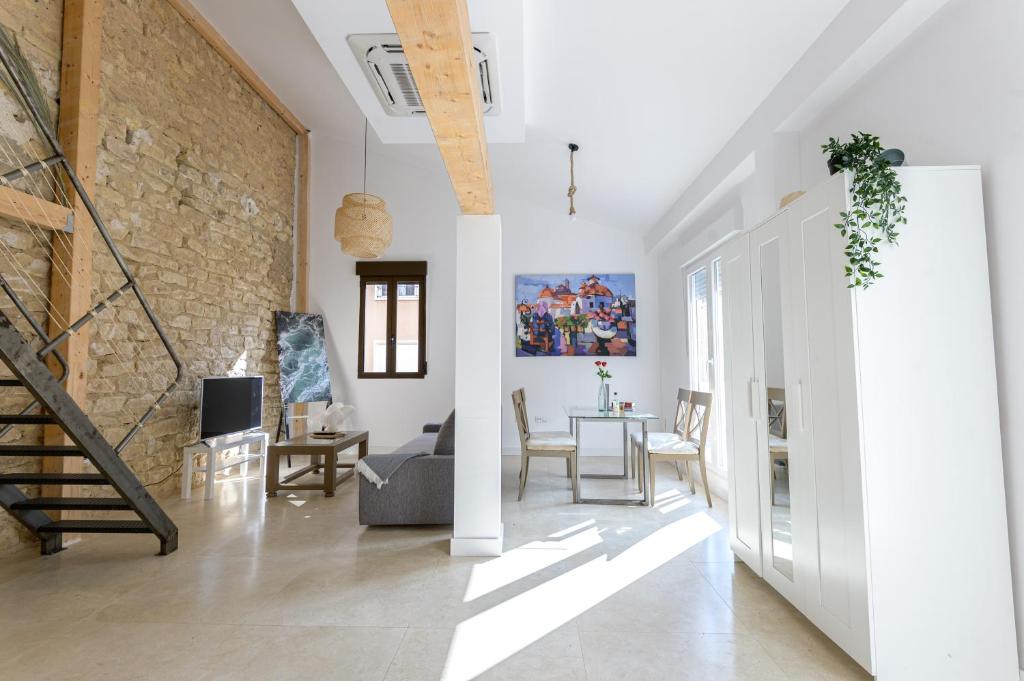 a living room with a staircase and a brick wall at Soho Boho Apartments - with sunny rooftop terrace and fiber optic internet in Alicante