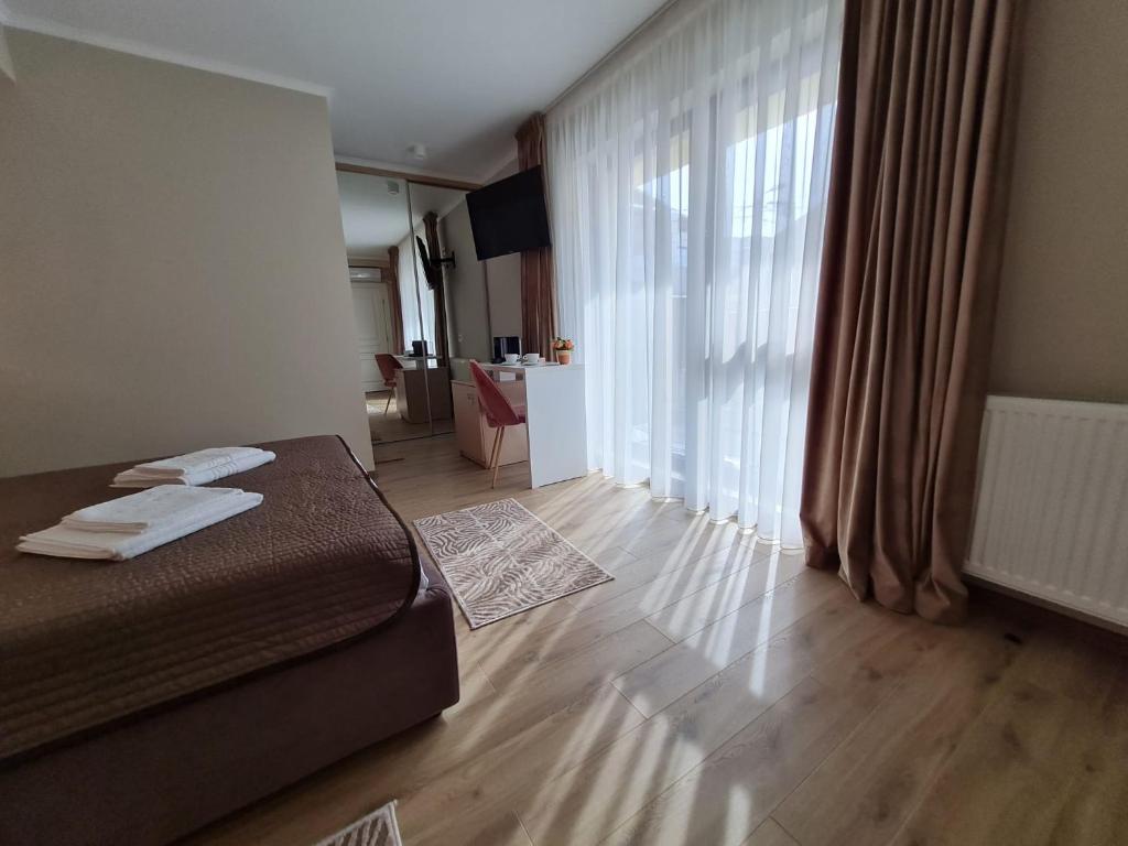 a bedroom with a bed and a large window at VILA MRV in Constanţa