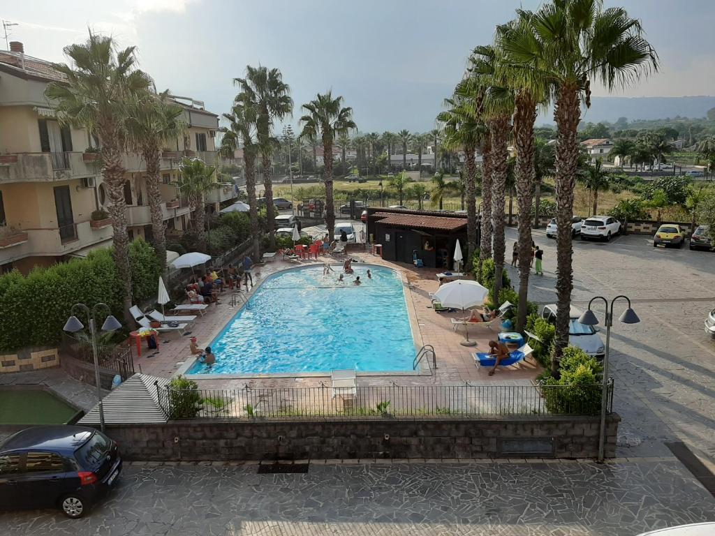 vista sul tetto di una piscina con palme di Casa, Mare-Etna-Taormina a Fondachello