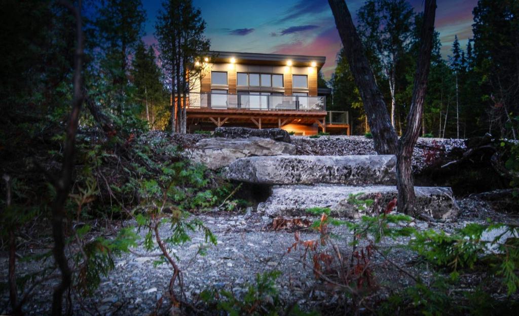 a house in the woods at night with lights at Stone Cove Waterfront Adults Only B&B in Tobermory