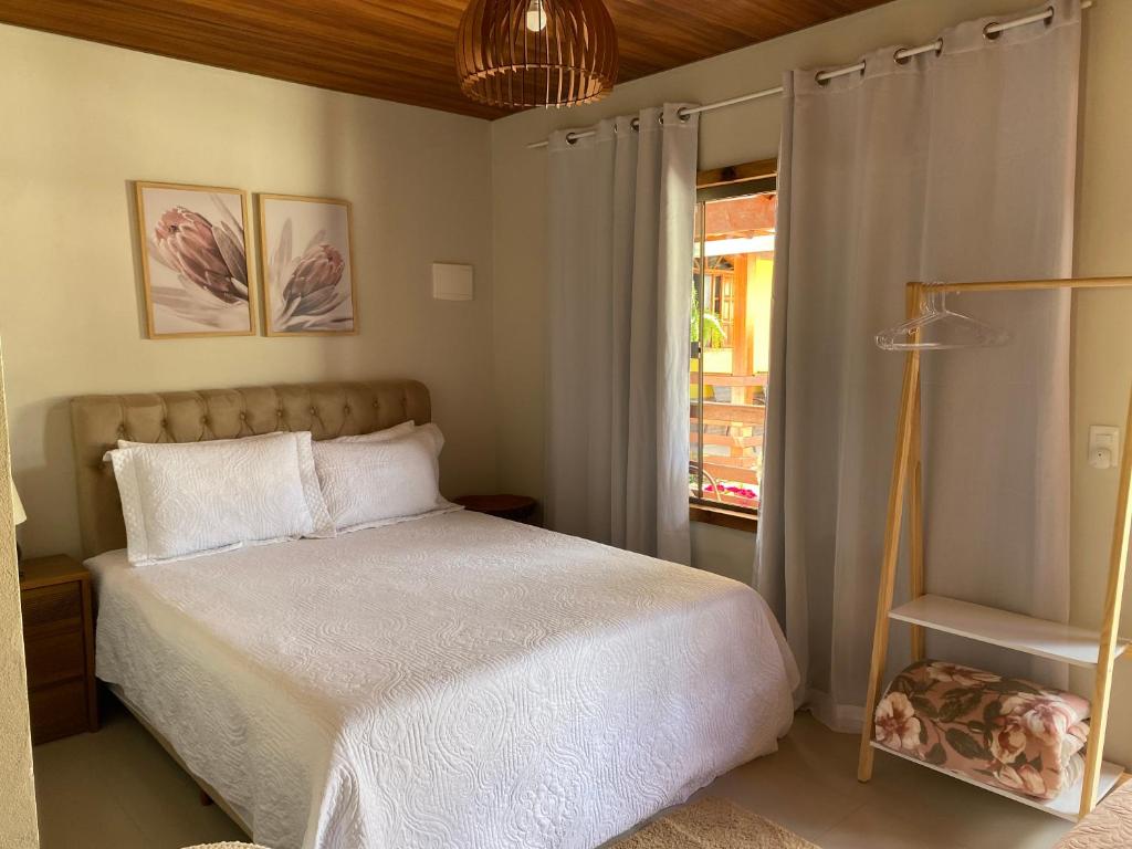 a bedroom with a white bed and a window at Pousada Rancho na Serra in Espera Feliz