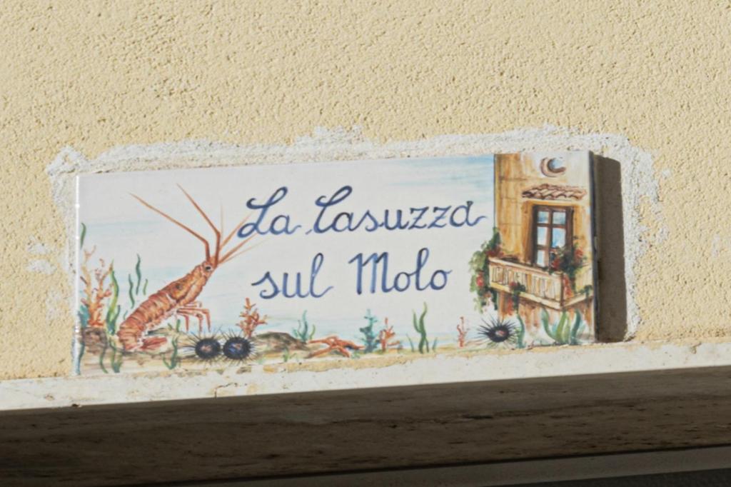 a picture on a wall with a sign on a shelf at La casuzza sul molo in Mazara del Vallo