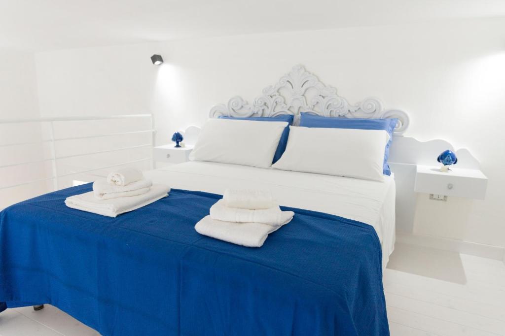 烏賈諾拉基耶薩的住宿－Alicam，蓝色和白色的卧室,配有带毛巾的床