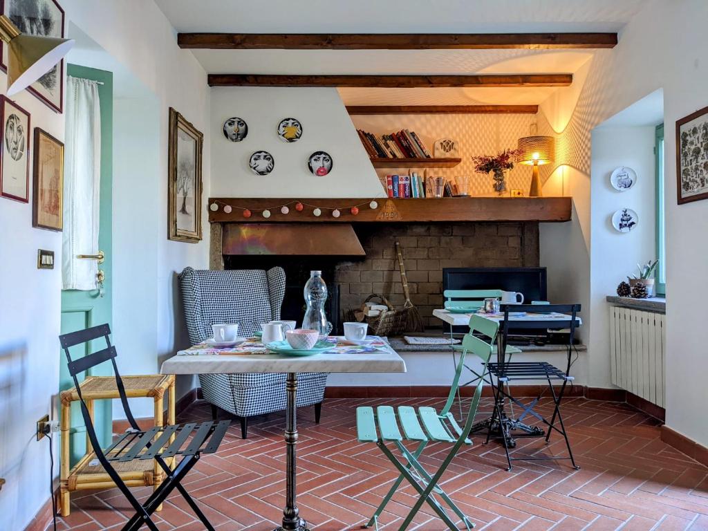 ein Wohnzimmer mit einem Tisch, Stühlen und einem Kamin in der Unterkunft B&B Il Poggiolo in Stresa