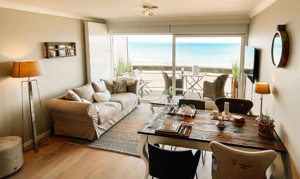 een woonkamer met een bank en een tafel met uitzicht bij la MERéMOI - Studio with balcony and sea vie in Oostende