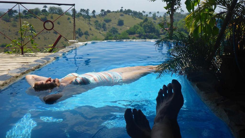 a person laying in the water in a swimming pool at Finca la Contenta in Jamao al Norte