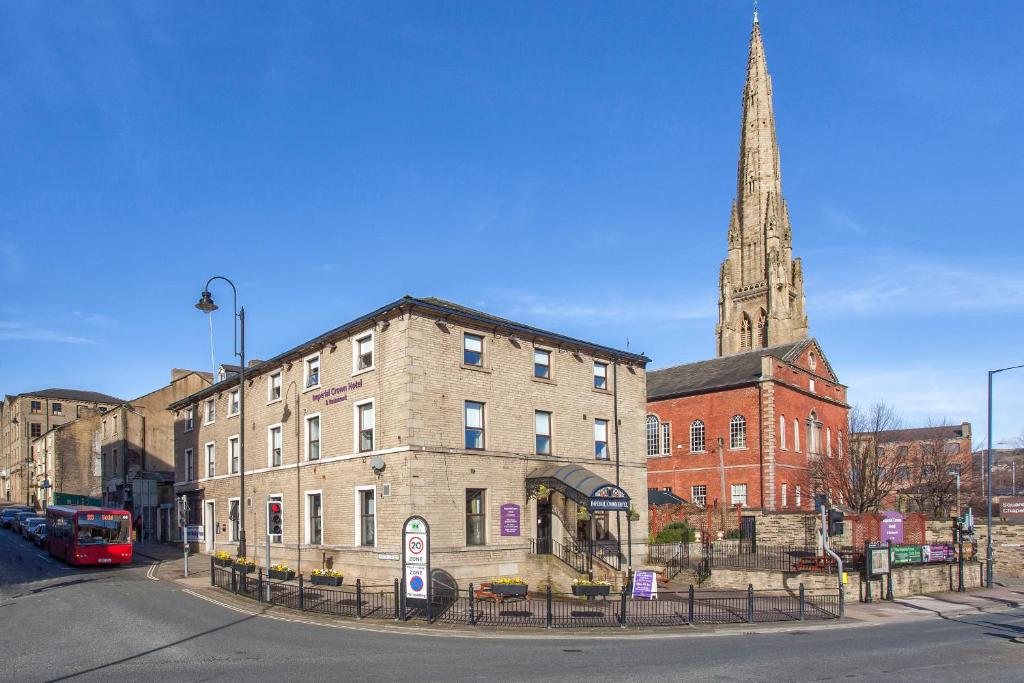 um edifício com um campanário e uma igreja com uma torre em The Imperial Crown Hotel em Halifax