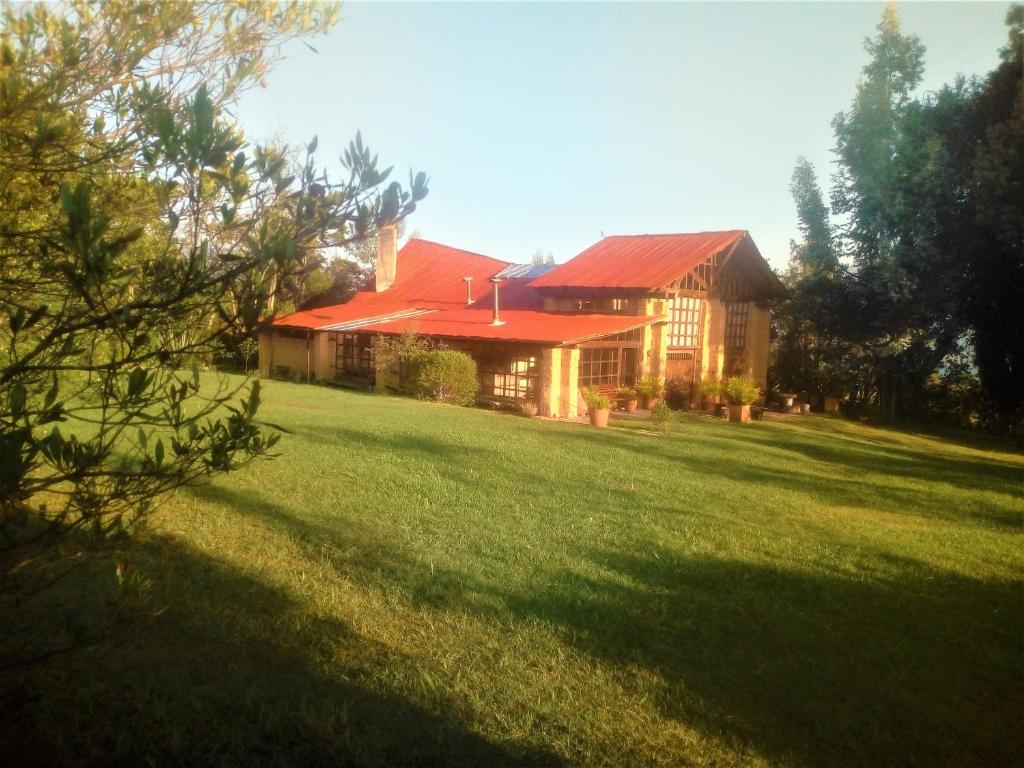 a large house with a large yard in front of it at Chalet Casa de Teja in Tinjacá