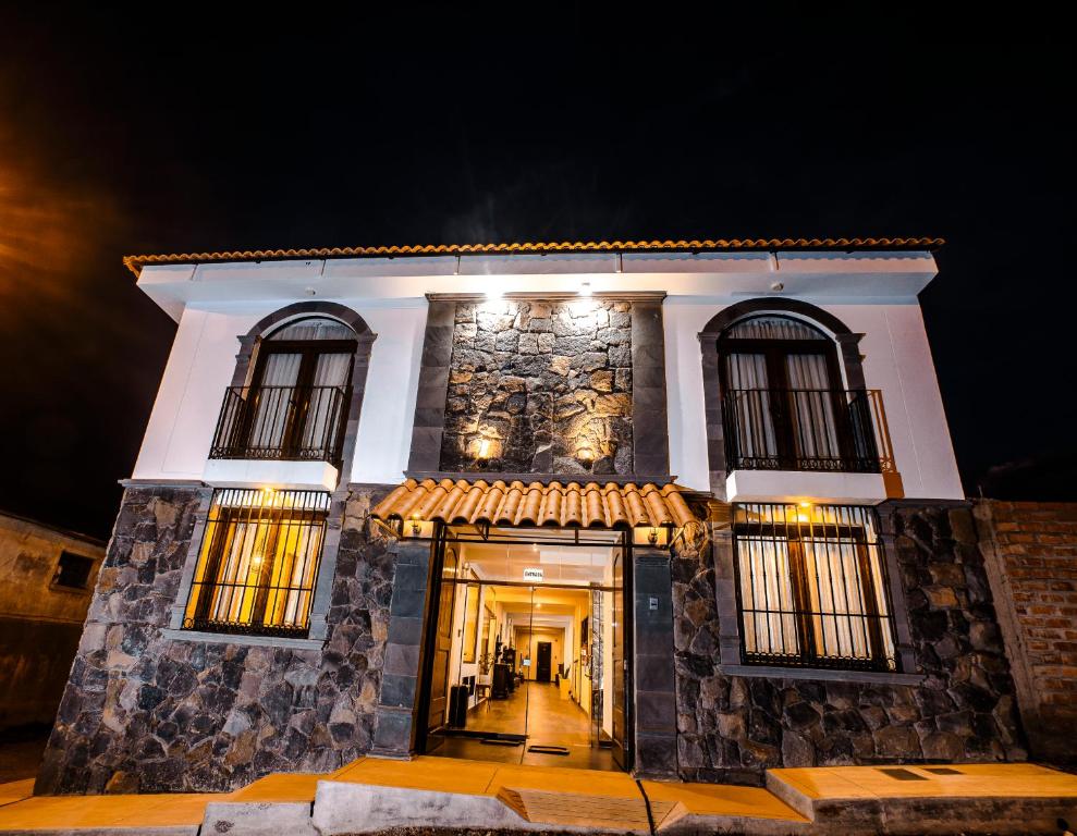 a large stone building with windows at night at ATOJJA CHUCUITO HOTEL in Puno