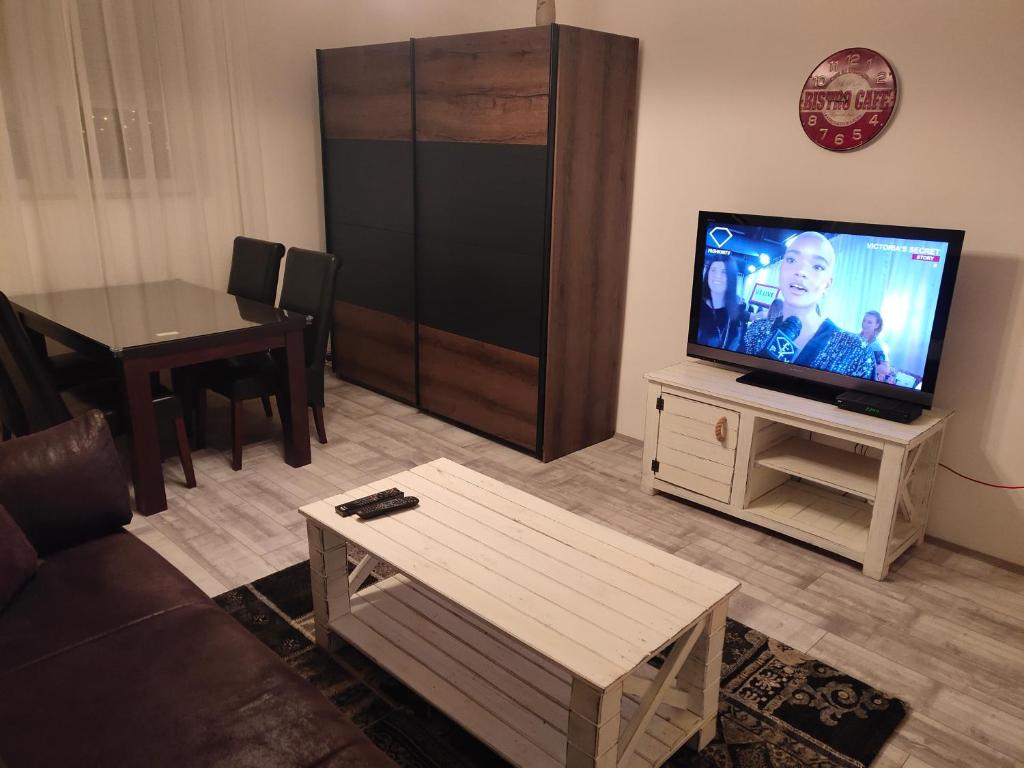 a living room with a flat screen tv and a table at Apartman Zemun Centar in Belgrade