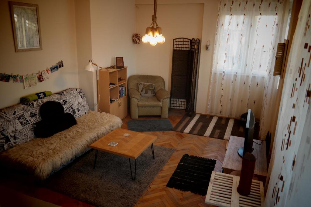 uma sala de estar com um sofá e uma cadeira em E-19 Home - Tradition meets tourism em Prizren
