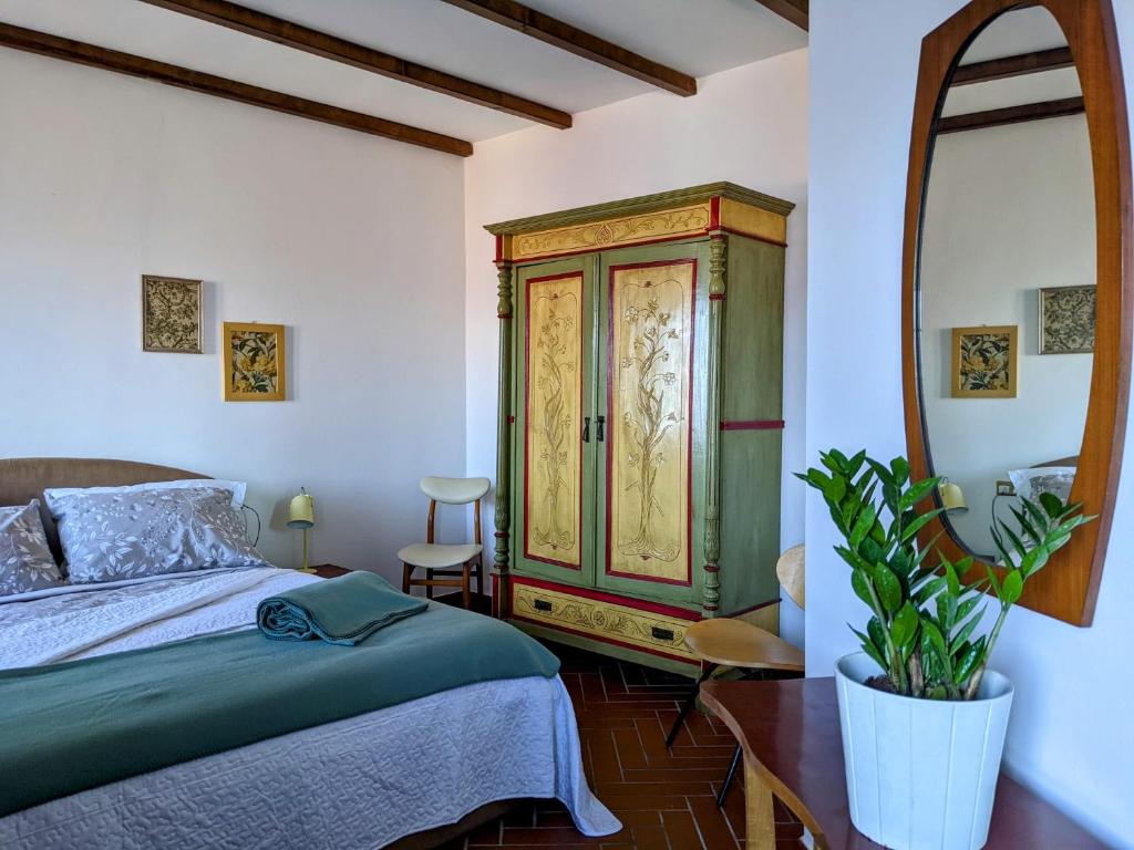sypialnia z łóżkiem i dużym lustrem w obiekcie B&B Il Poggiolo w mieście Stresa