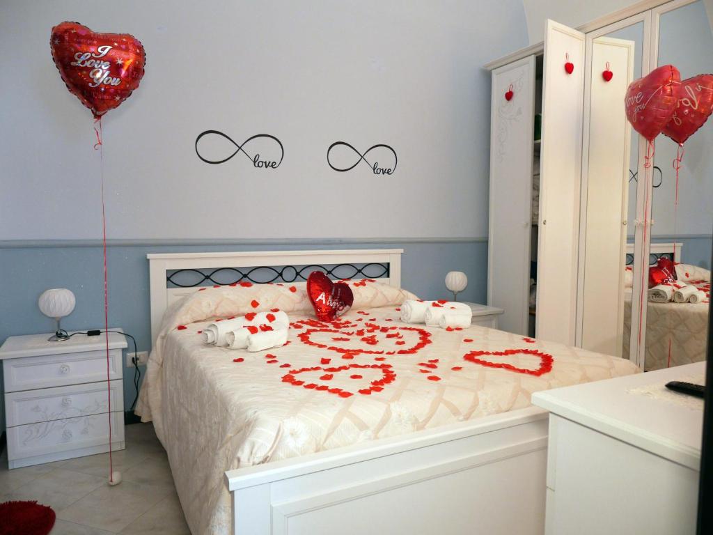 een slaapkamer met een bed met rode harten en ballonnen bij Lo scrigno del mare in Polignano a Mare