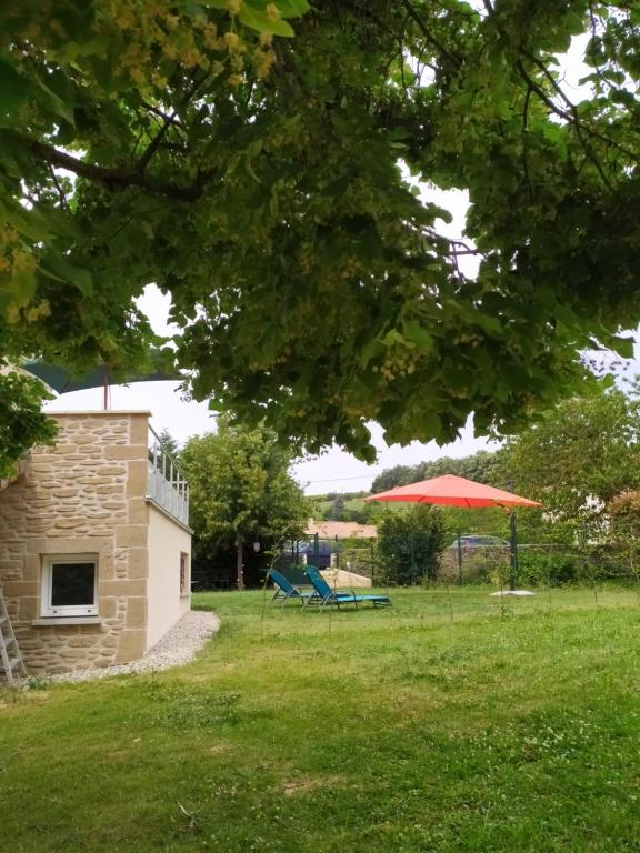 una mesa de picnic y una sombrilla en un patio en Gîte du Soleil Levant - Drôme des collines, en Bren