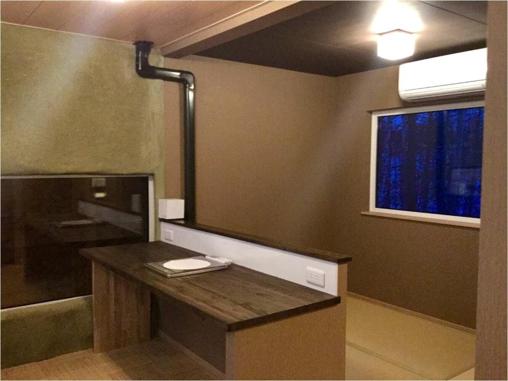 La salle de bains est pourvue d'un bureau et d'un grand miroir. dans l'établissement Auberge Ninguruforet, à Biei