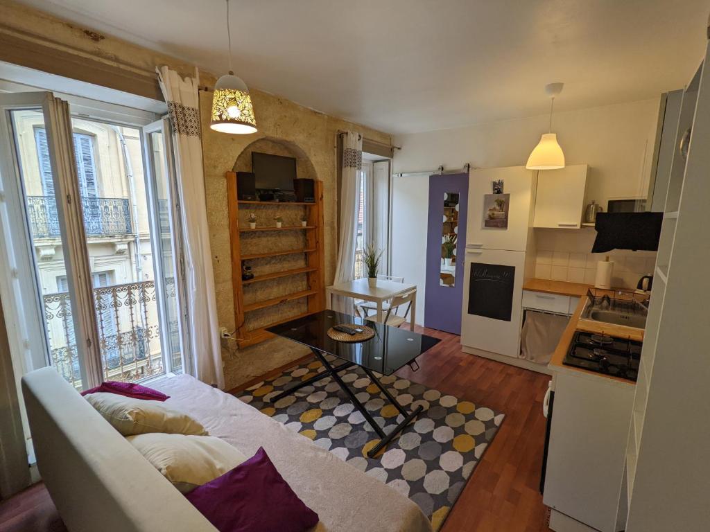 ein Wohnzimmer mit einem Sofa und einer Küche in der Unterkunft Appartement - City center in Montpellier