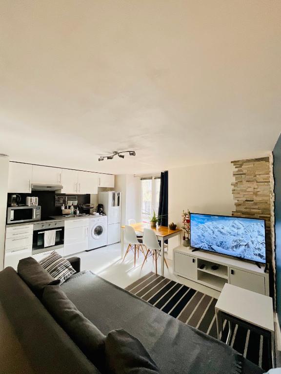 ein Wohnzimmer mit einem Sofa und einer Küche in der Unterkunft Dupleix Centre Ville Montlhéry Parking 30min Paris in Montlhéry