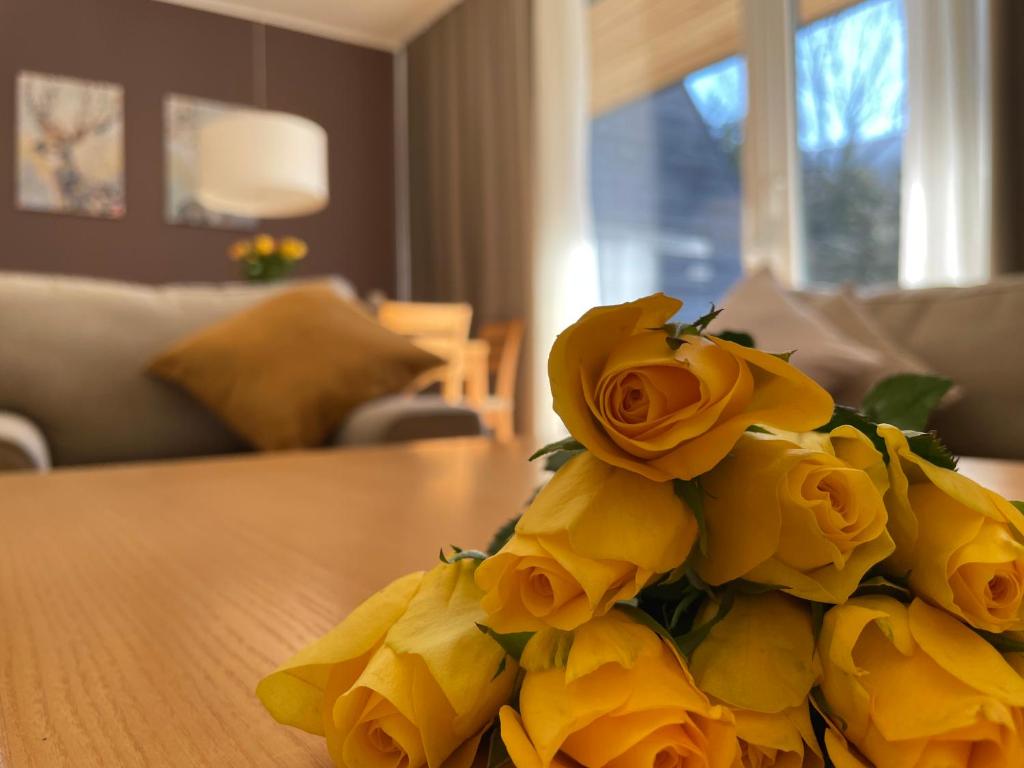 un montón de rosas amarillas sentadas sobre una mesa en JZ Apartments - Pohorje, en Maribor