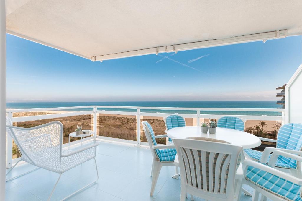 a balcony with a table and chairs and the ocean at Ag Aiguablava in Gandía