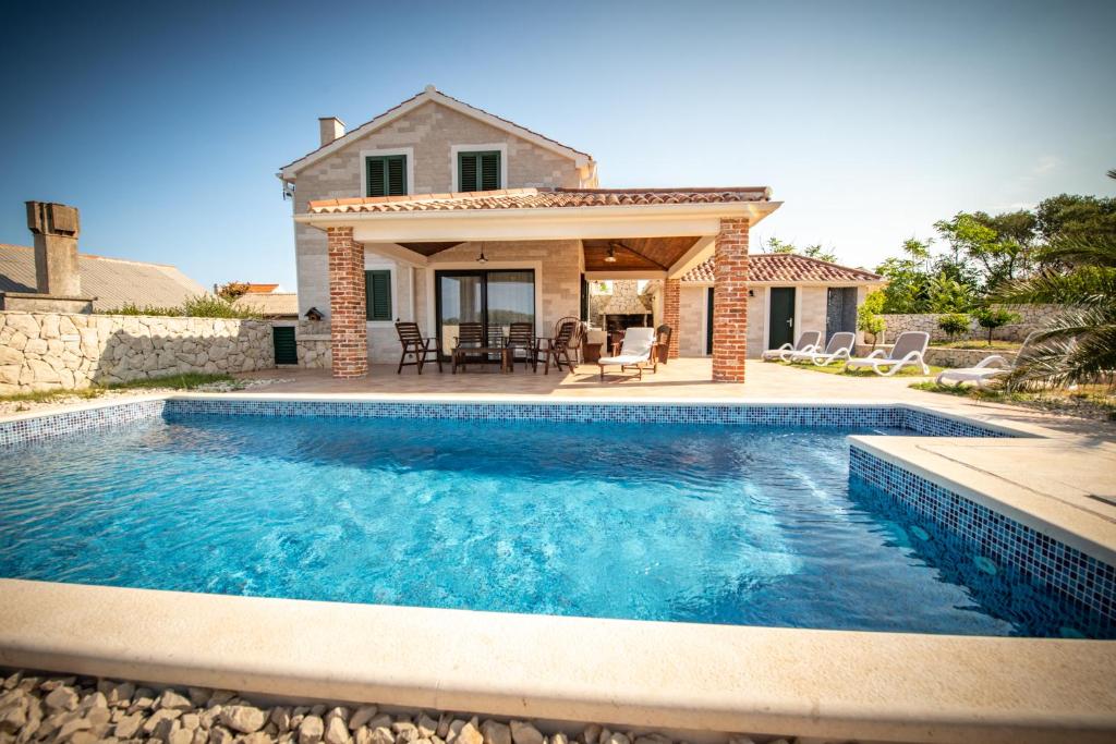 a swimming pool in front of a house at Villa Molat in Molat