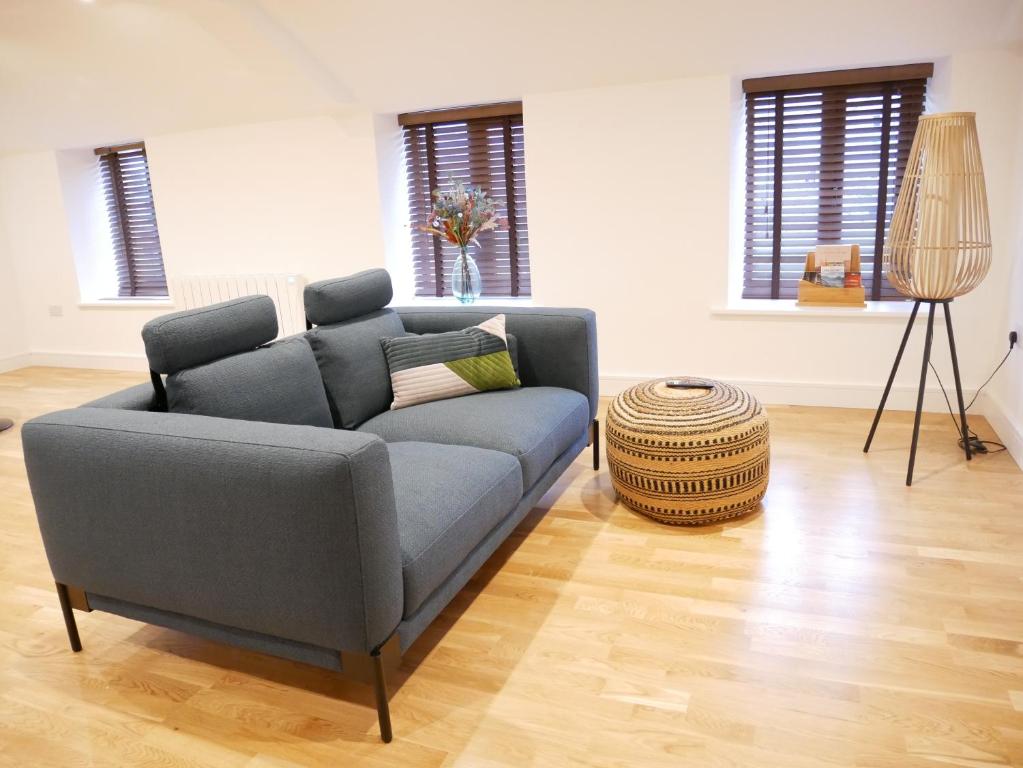 a living room with a blue couch and a wooden floor at Scandic Apartment, Ulverston in Ulverston