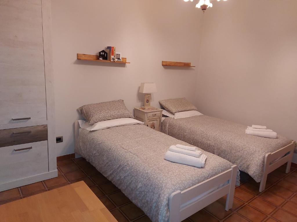 2 camas individuales en una habitación con lámpara en Casa dell'Agrifoglio, en Caselette