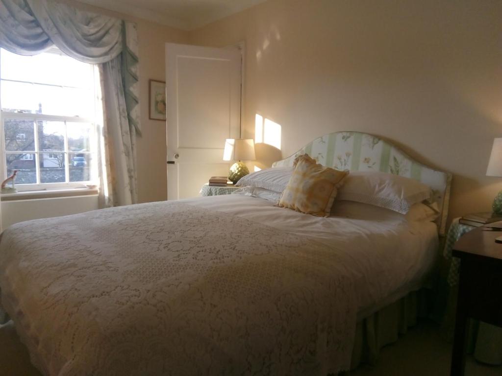 a bedroom with a white bed and a window at The Dower House in Fakenham