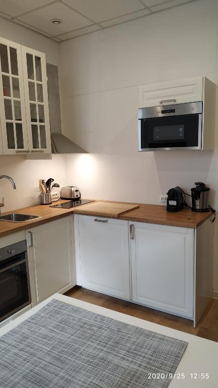 une cuisine avec des armoires blanches et un comptoir dans l'établissement Studio Neuf climatisé tout équipé #2, à Toulon