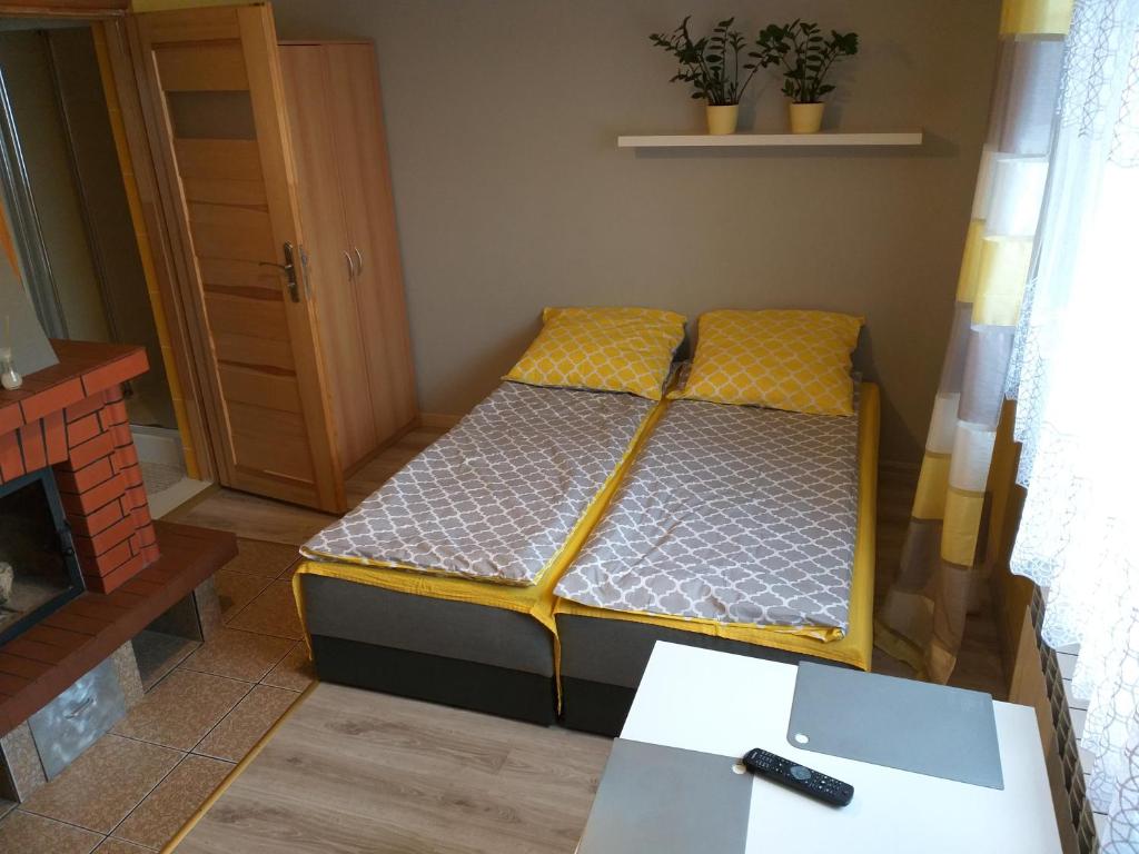 フミエルノにあるPokoje gościnne u Jasia i Małgosi w Chmielnie na Kaszubachのベッド2台とテーブルが備わる小さな客室です。